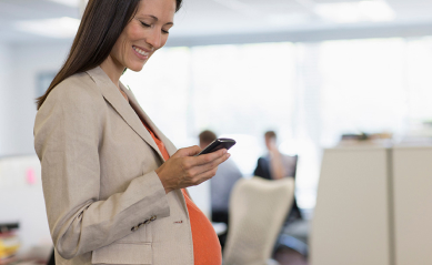 Pregnant businesswoman using smart phone in office 1